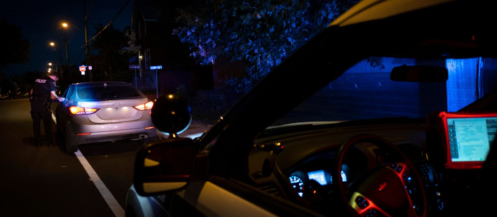 Ottawa Police member conducting a traffic stop at night.