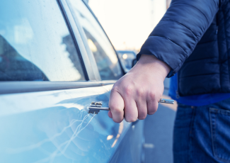Damage/mischief to vehicle: a person using a key to scratch a vehicle.