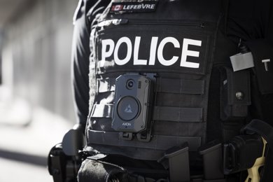 Photo of a police officer's uniforn, including a body worn camera affixed to the front vest.