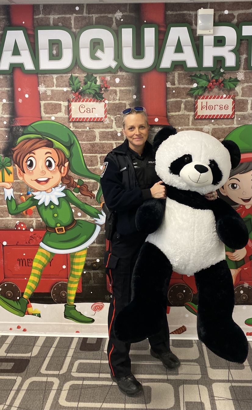 Constable Tricia Nesbitt holding a giant stuffed panda bear